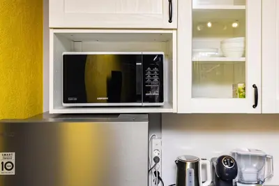 a microwave on top of a refrigerator in a kitchen at Bright Windowed Studio 10 mins to the City Centre by Flat Mаnager in Plovdiv