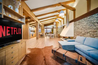 a living room with a blue couch and a tv at Bansko Lux Villas for Ski & Chill in Razlog