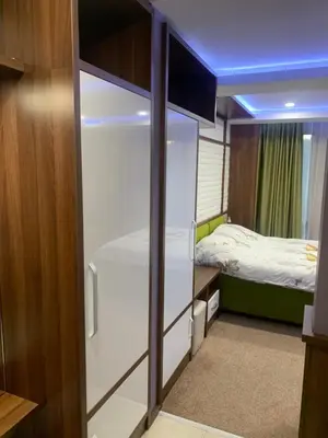 a small bedroom with a bed and a glass closet at Уютная студия Green Life E 04 in Bansko