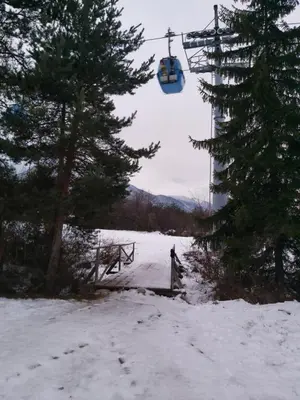 a person riding a ski lift in the snow at Bella Si Relax in Bansko