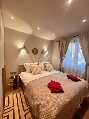 a bedroom with a large bed with red towels on it at Cozy design 1 bedroom apartment in Bansko