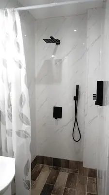 a bathroom with a shower with a black umbrella on the wall at Apartment Hangar 94 - Top Center - plus Free Vouchers in Sofia