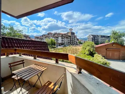 a balcony with a wooden table and chairs on a roof at One-bedroom Apartment at Belvedere Holiday Club Complex in Bansko