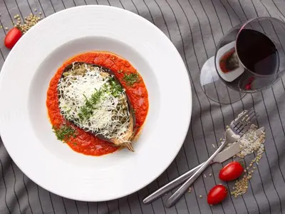a white plate with a pasta dish with cheese and sauce at The Mirror Apartment in Sofia