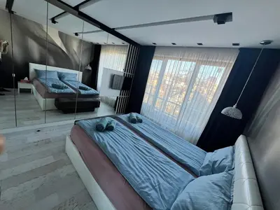 a bedroom with a bed and a couch and a mirror at The Mirror Apartment in Sofia
