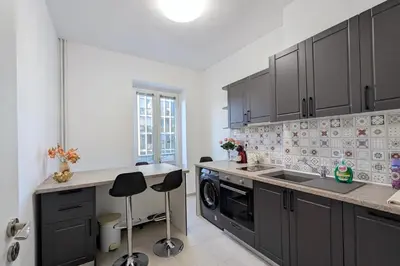 a kitchen with black cabinets and a sink at Sofia Office Loft in Sofia