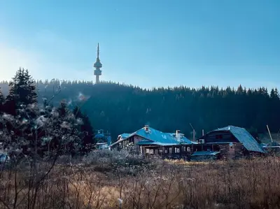 a group of houses in a field with a lighthouse in the background at Studio Béni in Smolyan