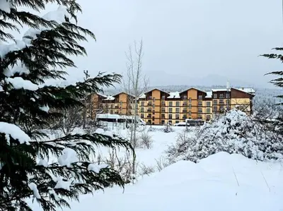 a large apartment building with snow on the ground at CROWN Apartment Bansko in Bansko