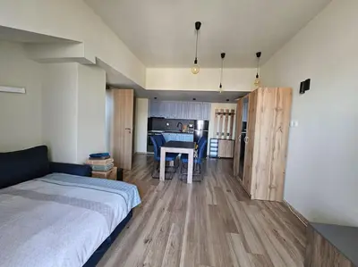 a bedroom with a bed and a kitchen with a table at CROWN Apartment Bansko in Bansko