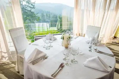 a table with wine glasses and napkins and a window at Pamporovo hotel Snezhanka A640 in Pamporovo