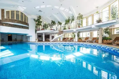 a large pool with blue water in a building at Pamporovo hotel Snezhanka A640 in Pamporovo