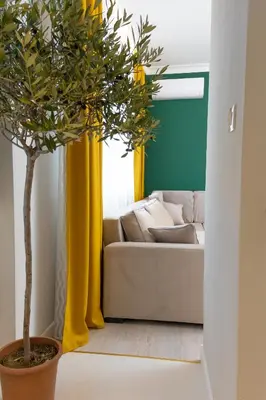 a living room with a couch and a potted tree at Contemporary Vintage, 3BDR Grace Suite in Sofia