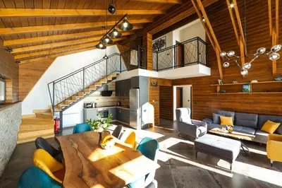 a living room with a wooden ceiling and a table at Lavalliere Hotel & Villas in Sarnitsa