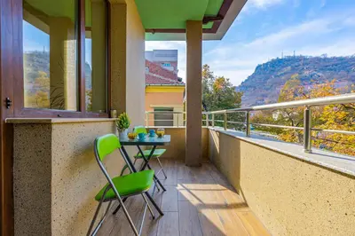 a balcony with a table and two chairs on it at Two bedroom apt Karavelov with Private Parking Medical University in Plovdiv