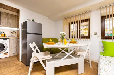 a kitchen and living room with a table and chairs at Tiny Secret Place next to MU with Private Parking in Plovdiv