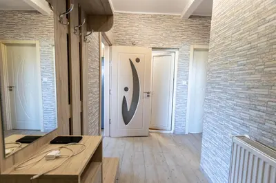 a hallway with a white door with a large letter on it at Къща за гости Дар in Batak