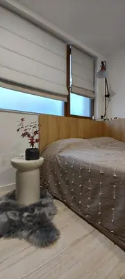 a bedroom with a bed and a table with a plant at Leaf apartment in Blagoevgrad