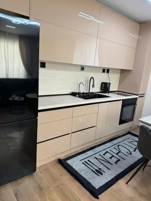 a kitchen with white cabinets and a sink and a rug at Патилови in Sandanski