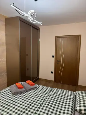 a bedroom with two beds and a sliding door at Патилови in Sandanski
