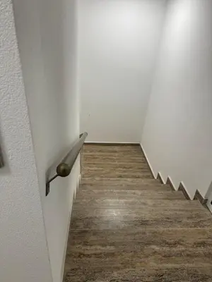 a stairway with a metal handle on a wall at Патилови in Sandanski