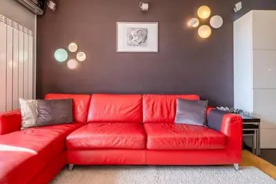 a red couch in a living room with a wall at iLonka's Home 1 BDR with Workspace and Terrace in Sofia