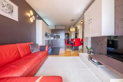 a living room with a red couch and a kitchen at iLonka's Home 1 BDR with Workspace and Terrace in Sofia