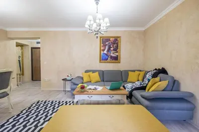 a living room with a blue couch and yellow pillows at The EGO house at Vitoshka Street in Sofia