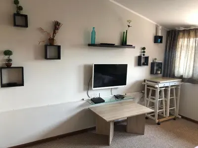a living room with a tv and a table at Rooftop Central Studio in Sofia