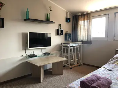a living room with a television and a desk with a table at Rooftop Central Studio in Sofia
