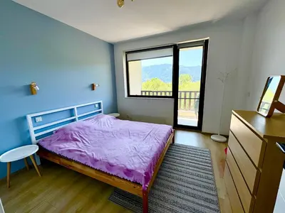 a bedroom with a purple bed and a window at Хубавото място - Ski & Relax next to Pamporovo in Smolyan