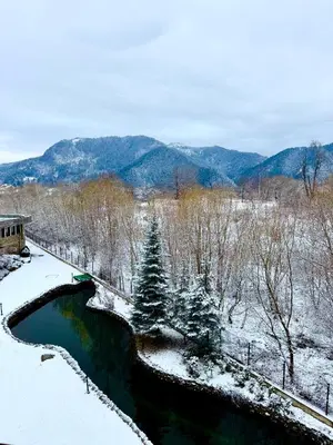 a bridge over a river in the snow at Хубавото място - Ski & Relax next to Pamporovo in Smolyan