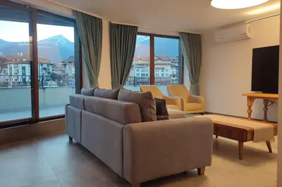 a living room with a couch and a tv at 4-bedrooms luxury apartment very close to ski lift in Bansko