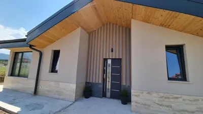 a house with a wooden roof and a door at Апартамент с двор Дива in Samokov