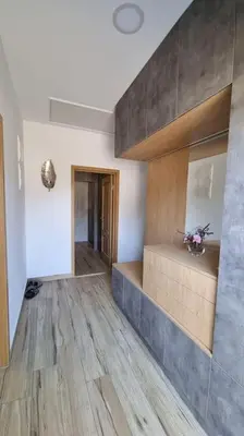 a living room with wooden floors and a staircase at Апартамент с двор Дива in Samokov