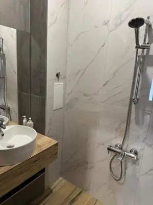 a bathroom with a sink and a shower at Апартамент с двор Дива in Samokov