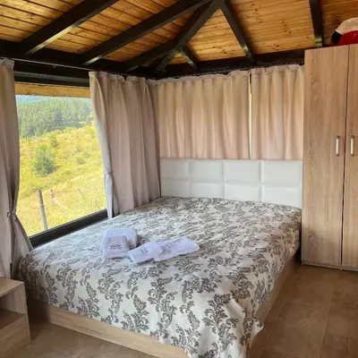 a bedroom with a bed with two towels on it at Вила Сънсет 1 in Dospat