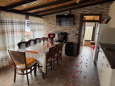 a dining room with a table and some chairs at Вила Сънсет 1 in Dospat