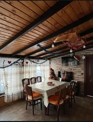 a dining room with a table and chairs at Вила Сънсет 1 in Dospat