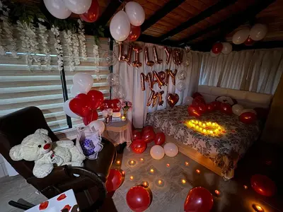 a room with balloons and a bed and a table at Вила Сънсет 1 in Dospat