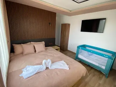 a bedroom with a bed with two towels on it at Вила Сънсет 2 in Dospat