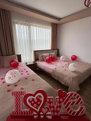 a room with two beds with red hearts on the floor at Вила Сънсет 2 in Dospat