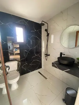 a bathroom with a toilet and a sink and a mirror at Вила Сънсет 2 in Dospat