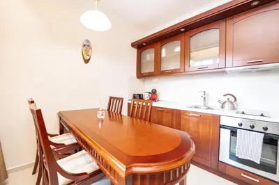 a kitchen with a wooden table and a sink at Host2U Slope-Side Home by the Gondola in Bansko