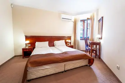 a bedroom with a large bed and a desk at Host2U Slope-Side Home by the Gondola in Bansko