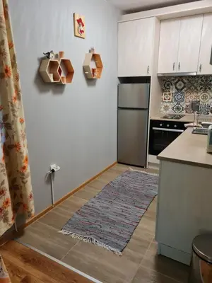 a kitchen with white cabinets and a refrigerator at South Park apartment free parking near Tokuda in Sofia