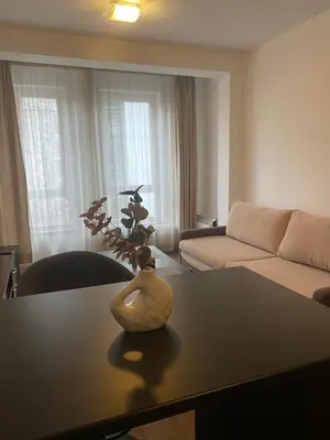 a living room with a table with a vase on it at Bansko Royal Towers Apartment - top location in Bansko