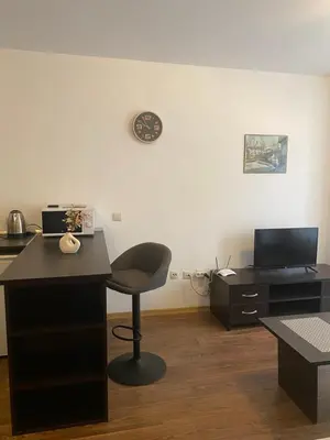 a room with a desk and a chair and a clock at Bansko Royal Towers Apartment - top location in Bansko