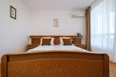 a bedroom with a large bed with a wooden headboard at The Hill House Free Parking in Plovdiv