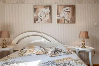 a bedroom with a white bed with three pictures on the wall at Aristocratic Elegant 2 BDRM spacious home TOP CENTER in Sofia