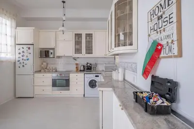 a white kitchen with white cabinets and a refrigerator at Aristocratic Elegant 2 BDRM spacious home TOP CENTER in Sofia